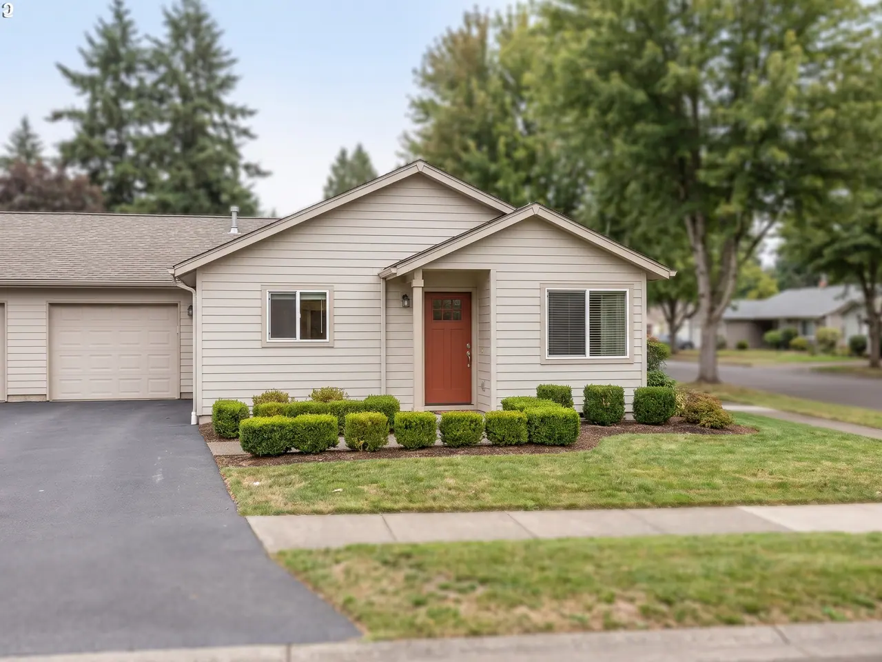 A single-story patio home with a tidy front garden in a 55+ community